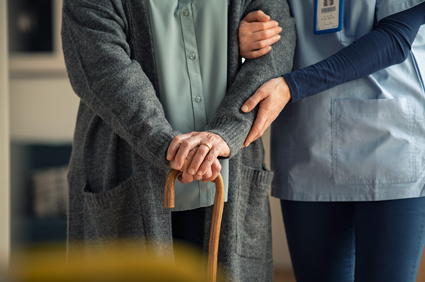 Nurse assisting elderly grandparent with walking during in-home care visit through House Call The App